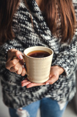 Girl's hands holding a cup of coffee