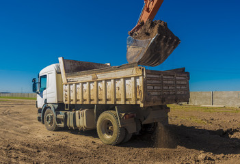 huge dump truck filled with excavated soil in Iraqi desert