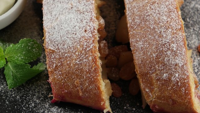 Apple pie (vienna strudel) with ice cream on black slate tray