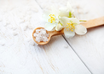 Spa composition with jasmine flowers and sea salt on white wooden table
