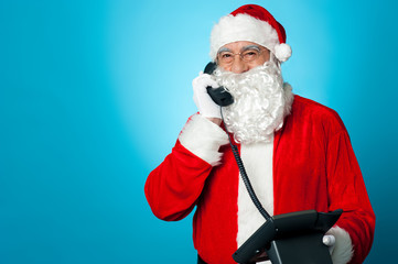Aged man in santa claus costume busy on call