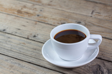 White cup of coffee on wood background