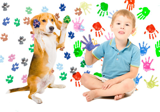 Happy boy with Beagle sitting  on the background of handprints