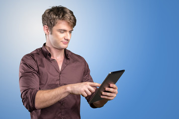 Smiling young man using tablet computer