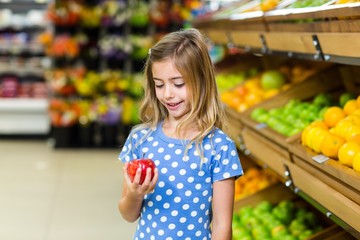 Cute kid looking at an apple