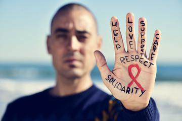 young man with a red ribbon for the fight against AIDS in his ha