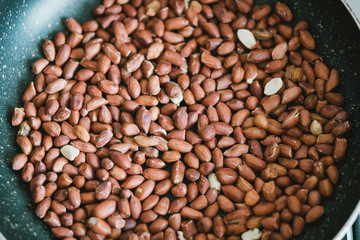 Peanuts in the shells in a frying pan close-up