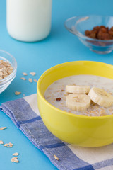 Breakfast porridge with bananas and raisins, vertical view