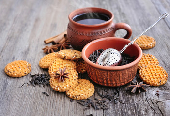 A cup of hot tea with cookies on a rustic wooden background