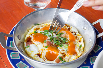 eating pan of fried eggs