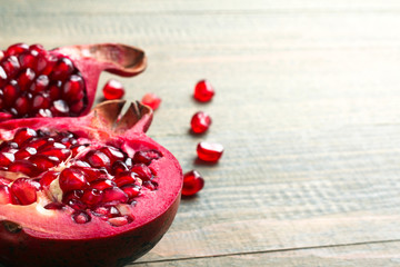 very juicy and big and delicious pomegranate in the section on wooden background isolated