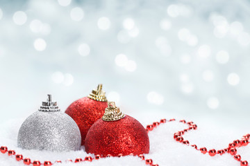 red and white christmas balls on snow 