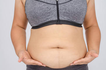 Woman's fingers measuring her belly fat