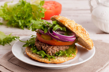 beef burger with vegetables on a plate, close-up