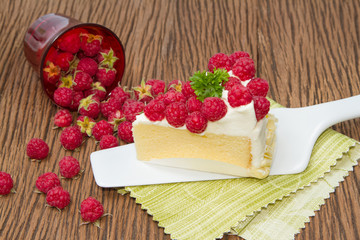 cheesecake with raspberries on wood background