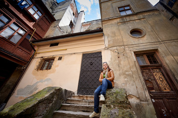 woman sitting on the stairs of an old building in the city