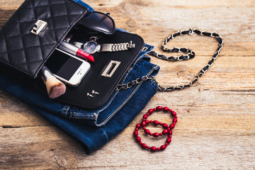Fashion accessories for a young girl, watch, bracelet, handbag, red lipstick, telephone, brush on a wooden background. - obrazy, fototapety, plakaty