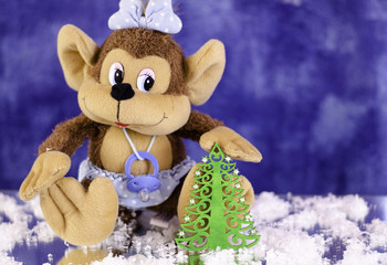 Christmas monkey with a bow. With the Christmas tree in his paws