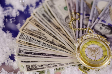 Christmas pocket watch against the background of dollar bills of