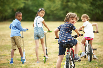 Kinder mit Mountainbikes und Tretroller