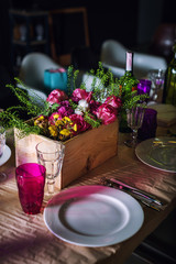Decorated table ready for dinner. Beautifully decorated table set with flowers, candles, plates and serviettes for wedding or another event in the restaurant.