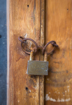Old rusty lock on wooden door closeup.