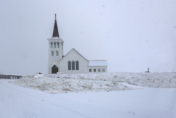Fototapeta na wymiar Small church in landscape at Iceland, falling snow