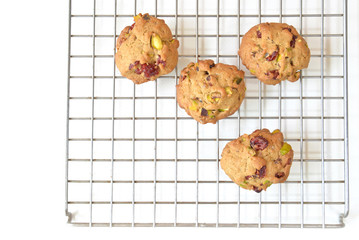 Homemade pistachio and cranberry cookies on cooling rack.
