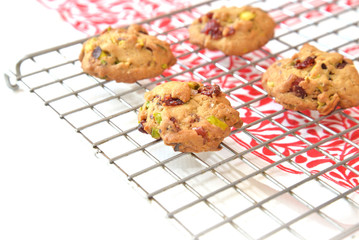 Homemade pistachio and cranberry cookies on cooling rack.
