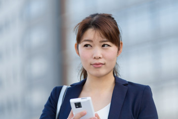スマホを触るOL(ビル)