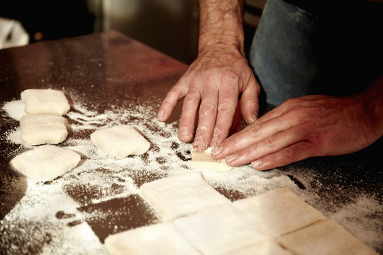 Baker preparing dough squares