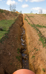  Larga zanja o alcantarilla recien construida, en los bordes de un camino de terreno arcilloso