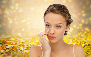 Fototapeta premium young woman applying cream to her face
