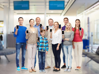 group of smiling people with smartphones