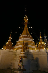 white and golden buddhist pagoda monument at night