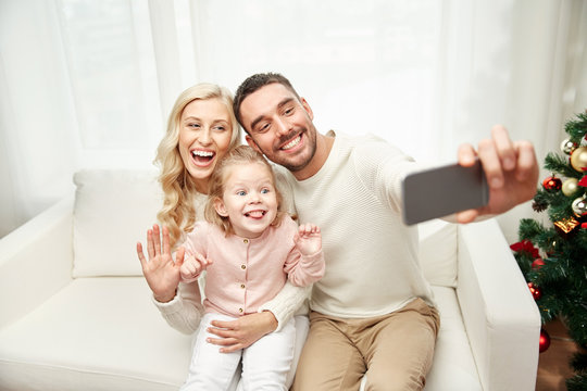family taking selfie with smartphone at christmas