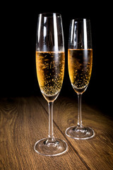 Two flutes of champagne on black background