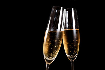 Two flutes of champagne on black background