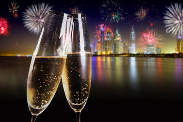Two flutes of champagne over fireworks display
