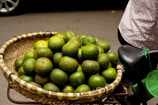 A basket of green limes on the back of a bicycle in Hanoi, Vietnam