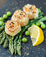 Scallops with sesame seeds, asparagus, lemon and green peas 