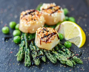 Keuken foto achterwand Sint-jakobsschelpen met sesamzaad, asperges, citroen en doperwtjes © la_vanda