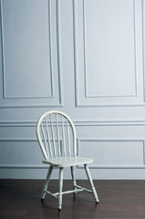 Empty chair agains blue wall.