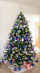 Fototapeta na wymiar Regali di Natale sotto un grande albero natalizio