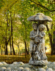 Fototapeta na wymiar Young couple under an umbrella in the park