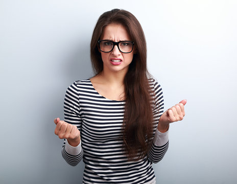 Nervous angry young woman in glasses with aggressive negative fa