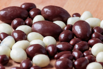 Chocolate dragee on wooden background.