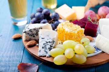 Cheese plate with fresh grape, honey, nuts,plum jelly, marmalade