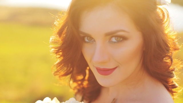 Emotional touched beautiful brunette bride in white dress in wreath with make-up close-up shot in slow motion  close up
