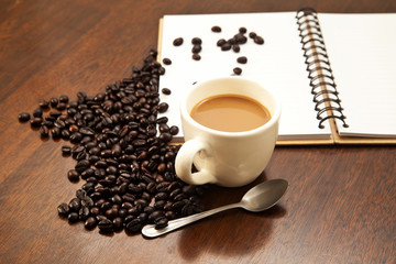 Cup of coffee and beans with book